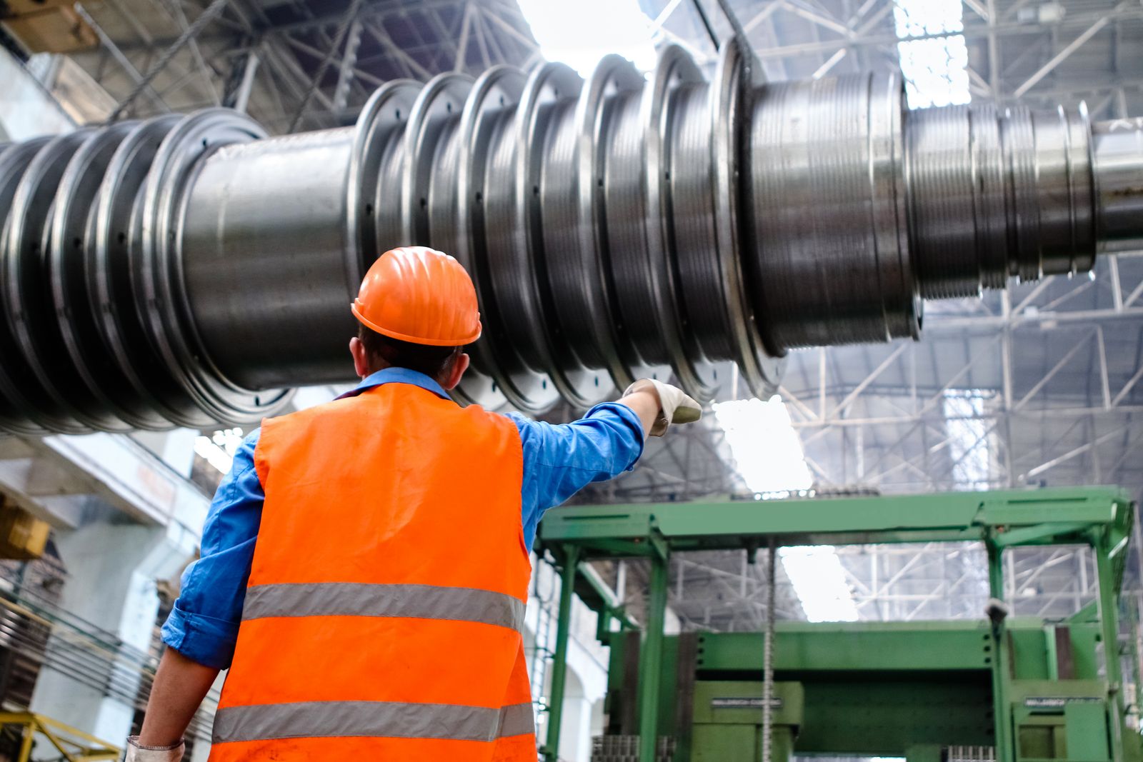 Industrial technician guiding the handling of large precision machinery