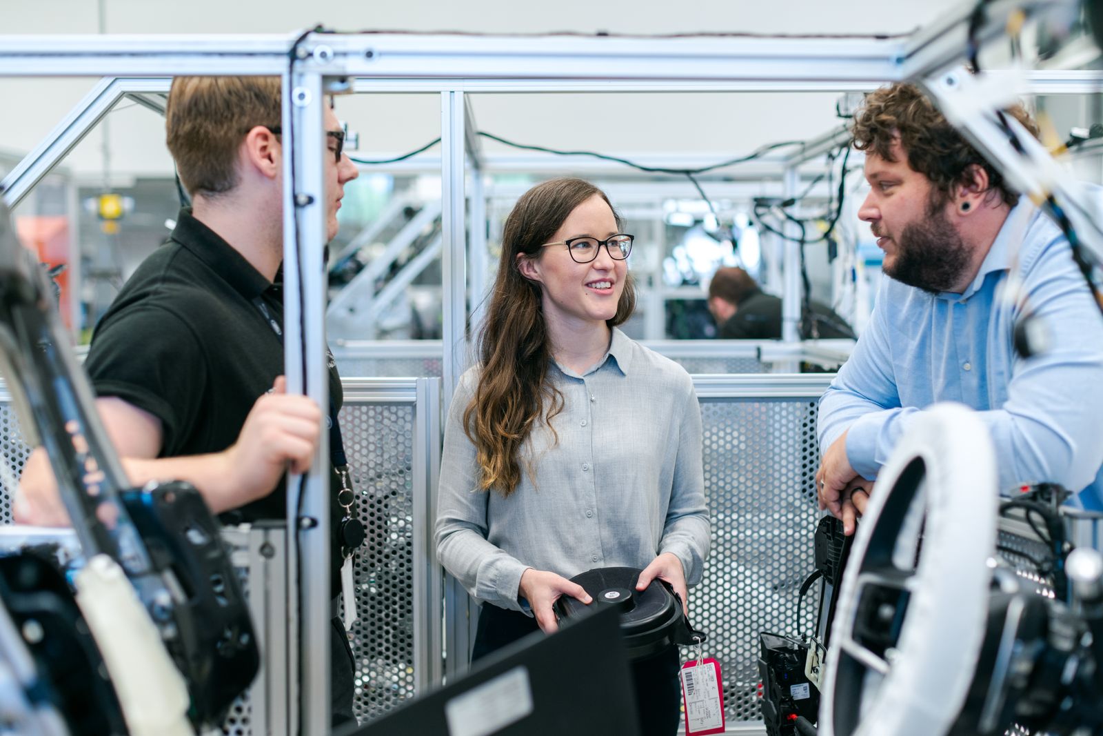 Engineering specialists collaborating beside advanced industrial equipment